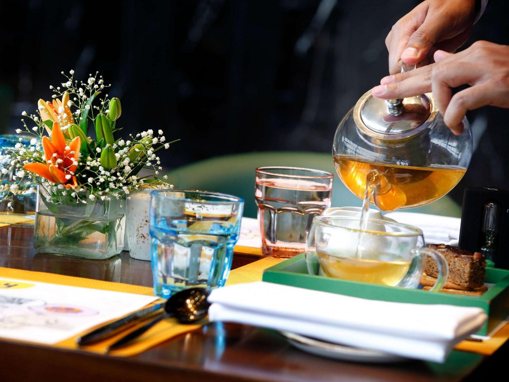 Novotel Kolkata Hotel And Residences Luaran gambar A server pours tea at a restaurant