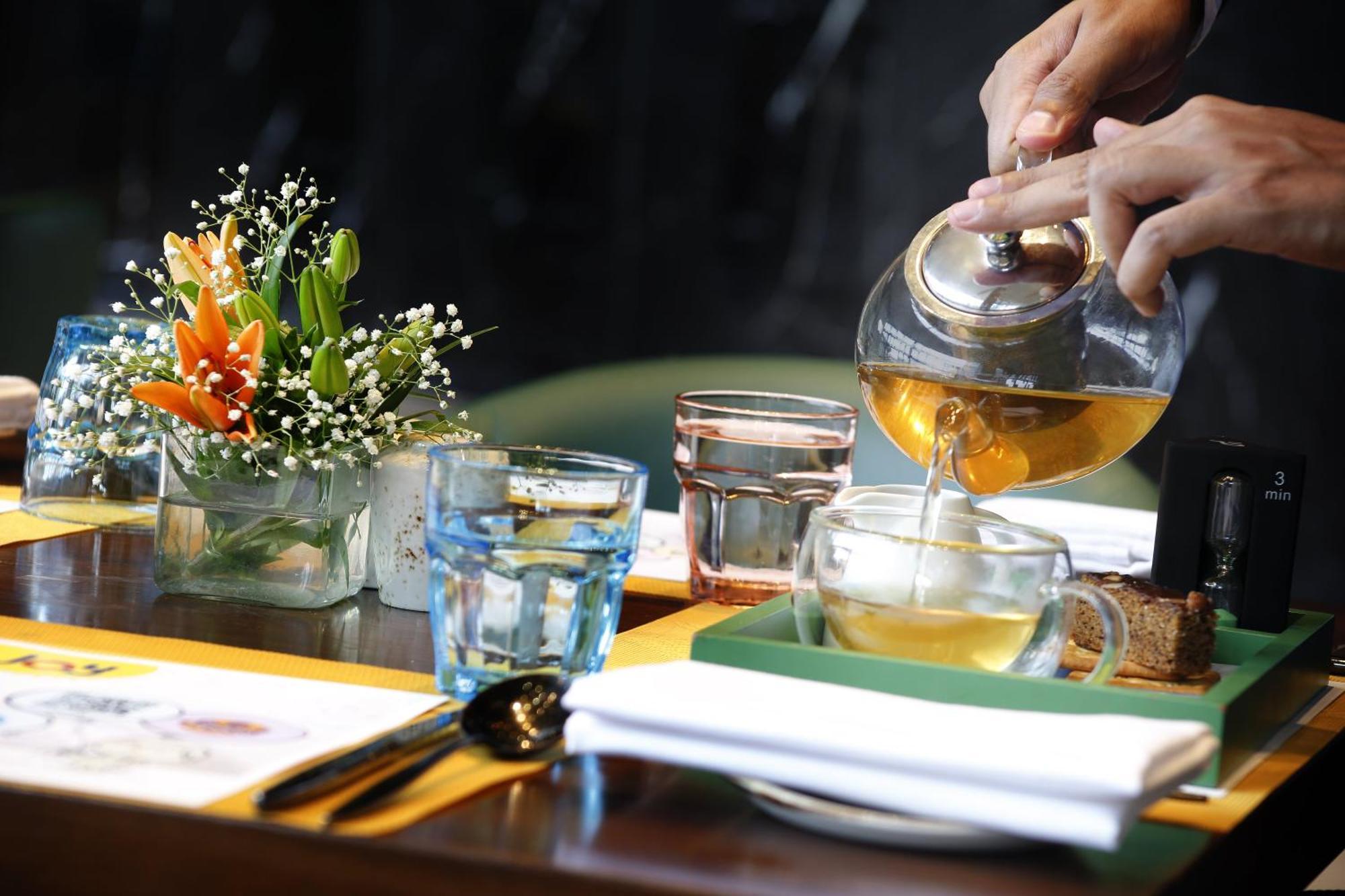 Novotel Kolkata Hotel And Residences Luaran gambar A server pours tea at a restaurant