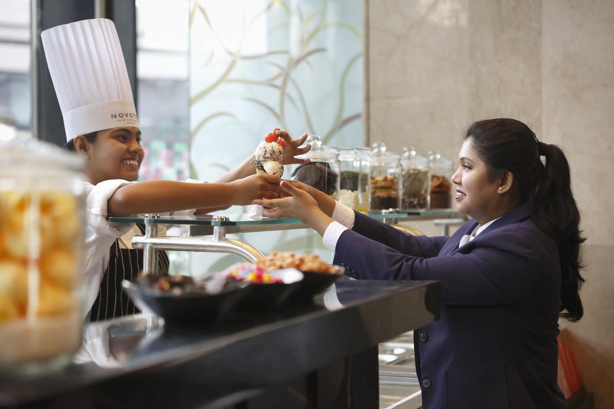 Novotel Kolkata Hotel And Residences Luaran gambar A chef serving food to a guest